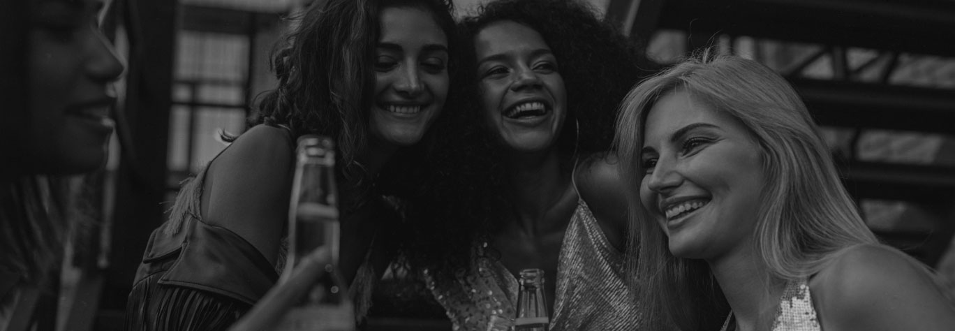 Friends laughing together with bottles of beer.
